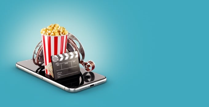 A smartphone displays popcorn, a clapperboard, and film reels, suggesting movie streaming on a mobile device against a light-blue background - phone-watch-movies