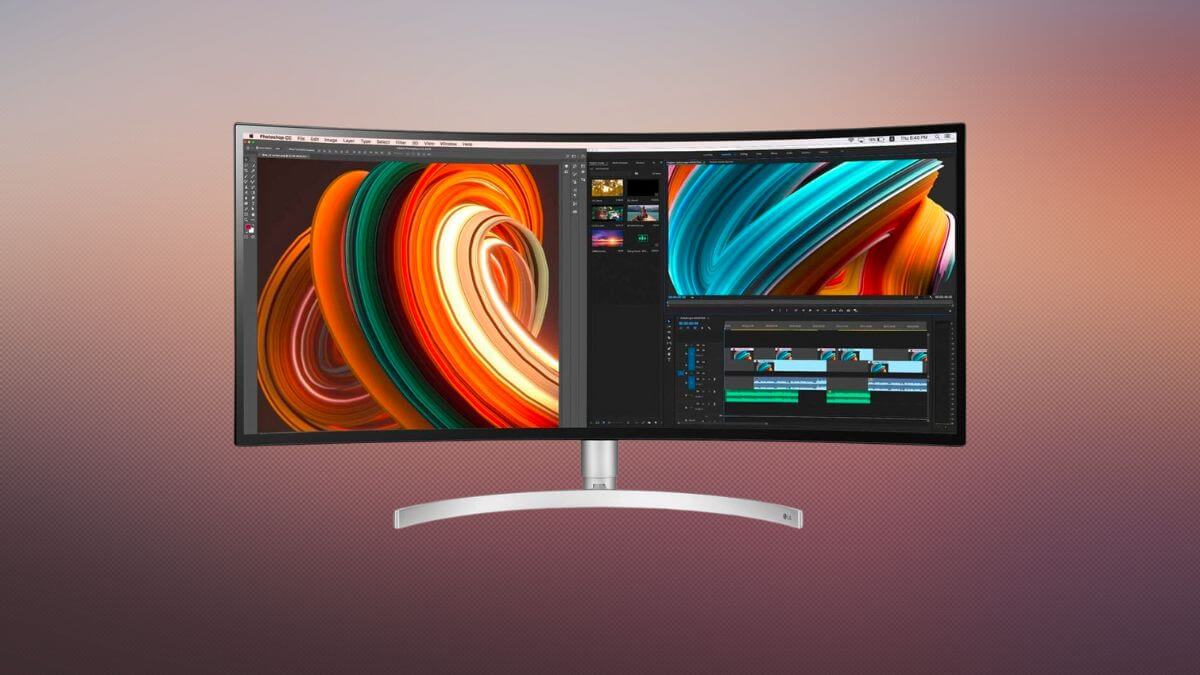 A curved monitor displays vibrant abstract artwork and video editing software
