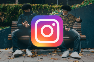 Two identical individuals sitting side-by-side on a bench with their faces obscured by a large Instagram logo icon